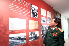 Trung tướng Phạm Tuân nhìn lại hình ảnh của chính mình trong trân chiến 50 năm trước. (Ảnh: Minh Thu/Vietnam+)