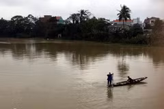Thả lưới trên sông Như Ý, trong khi nước lũ đang cao, bất chấp nguy hiểm. (Ảnh: Quốc Việt/Vietnam+)