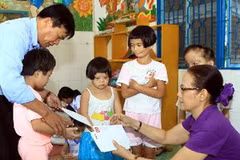 Đại diện Quỹ "Vì nỗi đau da cam " của TTXVN tổ chức thăm hỏi, tặng quà cho 10 trẻ em nhiễm chất độc da cam/dioxin. (Ảnh: TTXVN) 