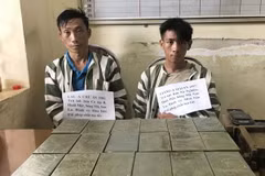 Hai đối tượng Lầu A Chừ và Giàng A Mai cùng tang vật vụ án. (Ảnh: TTXVN phát)