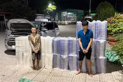 Hai đối tượng vận chuyển 15.000 bao thuốc lá ngoại nhập lậu bị bắt giữ cùng tang vật. (Ảnh: TTXVN phát)