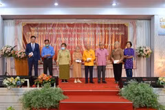 Thứ trưởng Phạm Quang Hiệu (ngoài cùng, trái sang) tặng quà cho các hội đoàn người Việt cùng một số kiều bào có công, kiều bào lão thành. (Ảnh: Hữu Kiên/TTXVN)