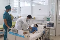 Bác sỹ thăm khám cho bệnh nhi bị sốc do sốt xuất huyết nặng. (Ảnh: Lê Thúy Hằng/TTXVN)