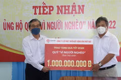 Chủ tịch Ủy ban Mặt trận Tổ quốc Việt Nam tỉnh Trà Vinh Nguyễn Văn Triết (trái) tiếp nhận 1 tỷ đồng hỗ trợ quà Tết hộ nghèo từ Công ty Cổ phần Phát triển Bất động sản Phát Đạt. (Ảnh: Thanh Hòa/TTXVN)