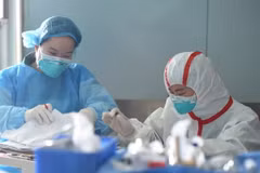 Nhân viên y tế Trung Quốc điều trị cho một bệnh nhân nhiễm virus cúm gia cầm H7N9 tại Trung tâm y tế Vũ Hán ở Hồ Bắc, miền trung Trung Quốc ngày 12/2. (Nguồn: EPA/TTXVN)