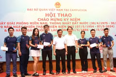 Đại sứ Việt Nam tại Campuchia Nguyễn Huy Tăng (giữa) trao giải Nhất, Nhì, Ba cho các vận động viên thi đấu môn cầu lông. (Ảnh: Hoàng Minh/TTXVN)