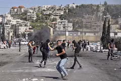 Người biểu tình Palestine ném đá về phía cảnh sát Israel trong cuộc đụng độ tại khu vực Đền Al-Aqsa ở Đông Jerusalem ngày 15/4. (Ảnh: AFP/TTXVN)
