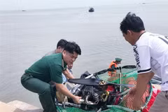 Lực lượng biên phòng trục vớt dù lượn bị rớt trên biển Cần Giờ. (Ảnh: TTXVN phát)