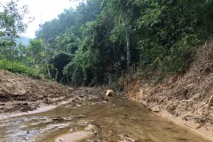 Suối Trầm đã được nạo vét rộng sang cả hai bên bờ để bóc tách lớp đất cùng thảm thực vật nhiễm dầu. (Ảnh: Sơn Bách/Vietnam+)
