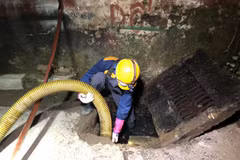 Nhân viên Công ty trách nhiệm hữu hạn Một thành viên Thoát nước Hà Nội khơi, hút cống rãnh khu vực Công ty Rạng Đông. (Ảnh Mạnh Khánh/TTXVN)