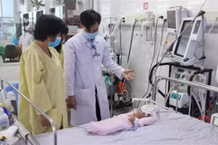 Bác sỹ Dương Thanh Tùng, Khoa Hồi sức tích cực (Bệnh viện Sản-Nhi tỉnh An Giang) thăm khám cho bệnh nhi. (Ảnh: Thanh Sang/TTXVN)