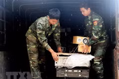 Kiểm đếm và vận chuyển tang vật buôn lậu hàng hóa vào kho tạm giữ. (Ảnh: Công Mạo/TTXVN)