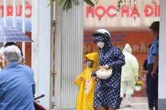 Các bậc phụ huynh đón con nhỏ tại Trường Tiểu học Hạ Đình, nơi cách hiện trường vụ cháy nhà xưởng Công ty Rạng Đông chưa đến 1km. (Ảnh: Thành Đạt/TTXVN)