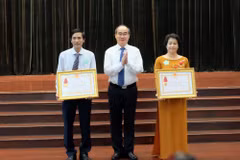 Bí thư Thành ủy Thành phố Hồ Chí Minh Nguyễn Thiện Nhân chúc mừng 2 tập thể có thành tích xuất sắc trong công tác giáo dục và đào tạo được nhận Huân chương Lao động hạng Ba. (Ảnh: Thu Hoài/TTXVN)