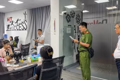 Cơ quan Công an đọc lệnh khám xét trụ sở công ty có hành vi vi phạm. (Ảnh: THN/Vietnam+)