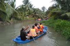 Du khách trải nghiệm hoạt động tự bơi xuồng trên sông trong Nông trại dê sữa du lịch Đông Nghi ở Tiền Giang. (Ảnh: Minh Hưng/TTXVN)