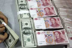Nhân viên kiểm đồng USD (trái) và đồng nhân dân tệ tại một ngân hàng ở tỉnh An Huy, Trung Quốc. (Ảnh: AFP/TTXVN)