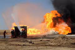 Nhân viên cứu hỏa Iraq nỗ lực khống chế đám cháy tại mỏ dầu Khabbaz sau vụ tấn công do các phần tử khủng bố IS tiến hành ngày 1/6/2016. (Ảnh: AFP/TTXVN)