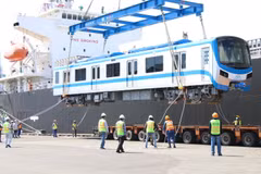 Toa xe đầu tiên của đoàn tàu số 4 được cẩu khỏi tàu vận chuyển Pulang Tala và đặt xuống xe chuyên dụng. (Ảnh: Tiến Lực/TTXVN)