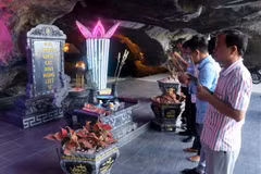 Du khách thắp hương tưởng niệm các Anh hùng liệt sỹ trước cửa hang Quân y núi Mo So, xã Bình An, huyện Kiên Lương. (Ảnh: Lê Huy Hải /TTXVN)