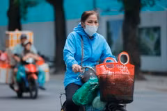Nhiều người ra đường đã phải mặc áo khoác để giữ ấm. (Ảnh: Minh Quyết/ TTXVN)