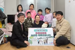 Giám đốc Văn phòng Jung-gu Kim Gil-sung trao số tiền trợ cấp khuyến khích sinh đông con cho vợ chồng Jeon Hye-hee và Jo Yong-seok ở Seoul. (Văn phòng Jung-gu)