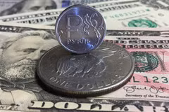 Đồng xu ruble của Nga (phía trên) và đồng USD tại Moskva. (Ảnh: AFP/TTXVN)