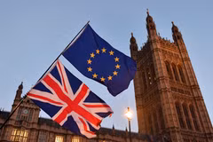 Cờ Anh (phía dưới) và cờ EU (phía trên) bên ngoài tòa nhà Quốc hội Anh tại London. (Ảnh: AFP/TTXVN)