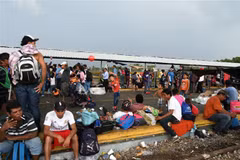 Người di cư trong hành trình đến Mỹ chờ đợi để đi qua khu vực biên giới từ Ciudad Tecun Uman, Guatemala, tới Ciudad Hidalgo, Mexico, ngày 21/10/2018. (Nguồn: AFP/TTXVN) 