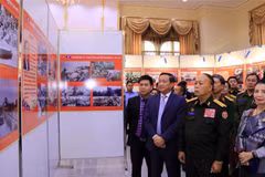 Thượng tướng Thongloy Silivong, Thứ trưởng, Chủ nhiệm Tổng cục Chính trị Bộ Quốc phòng Lào và Đại sứ Việt Nam tại Lào Nguyễn Bá Hùng cùng các quan khách tham quan Triển lãm. (Ảnh: Phạm Kiên/TTXVN) 