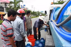 Người dân Rạch Giá phải sử dụng mọi vật dụng hiện có để lấy nước tại các xe bồn cấp nước. (Ảnh: Trường Giang/TTXVN)