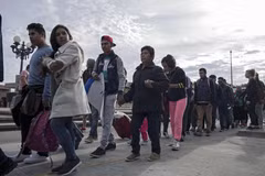 Người di cư Trung Mỹ vượt qua hàng rào biên giới khi di chuyển từ Tijuana, bang Baja California (Mexico) tới San Diego, Mỹ, ngày 21/3/2019. (Nguồn: AFP/TTXVN)
