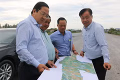 Phó Chủ tịch UBND tỉnh Long An Nguyễn Minh Lâm (trái) xem bản đồ đường Vành đai 3 Thành phố Hồ Chí Minh qua địa bàn tỉnh. (Ảnh: Thanh Bình/TTXVN)