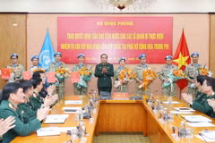 Thượng tướng Phùng Sĩ Tấn trao quyết định cho 4 sỹ quan và chúc mừng 4 sỹ quan đã hoàn thành nhiệm vụ. (Ảnh: Trọng Đức/TTXVN)