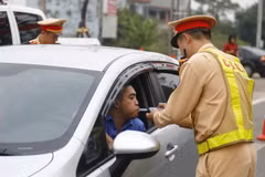 Cảnh sát giao thông kiểm tra nồng độ cồn của lái xe. (Ảnh: Nam Sương/TTXVN)