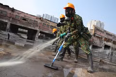 Lực lượng Binh chủng Hóa học phun hóa chất tẩy độc mặt nền nhà xưởng của Công ty Rạng Đông, ngày 5/10. (Ảnh: Dương Giang/TTXVN)