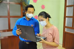 Phó Bí thư Thành đoàn Hà Nội Trần Quang Hưng trao tặng máy tính và túi an sinh cho cháu Nguyễn Thị Thu Phương có hoàn cảnh khó khăn tại huyện Thường Tín. (Ảnh: Minh Đức/TTXVN)