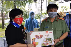 Bà Lê Thị Giàu, Chủ tịch Hội đồng quản trị Công ty Cổ phần Thực phẩm Bình Tây trao quà cho lực lượng làm nhiệm vụ tại khu cách ly tập trung tại Trường Đại học An Giang. (Ảnh: Thanh Sang/TTXVN)