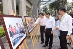 Bộ trưởng Bộ Thông tin và Truyền thông Trương Minh Tuấn và cán bộ, phóng viên TTXVN tham quan trưng bày ảnh Tuần lễ Cấp cao APEC 2017. (Ảnh: Doãn Tấn/TTXVN)