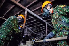 Lực lượng Binh chủng Hoá học thu gom chất thải, giải phóng hiện trường để tiến hành tẩy độc mặt nền nhà xưởng. (Ảnh: Dương Giang/TTXVN)