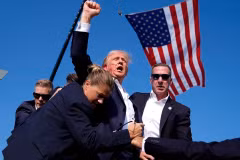Ông Donald Trump được mật vụ hộ tống khỏi sân khấu của sự kiện vận động tranh cử tại bang Pennsylvania sau khi xảy ra vụ nổ súng, ngày 13/7/2024. (Ảnh: AP/TTXVN)