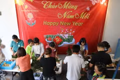 Các thành viên nhóm "New Sunlight For Children" gói bánh chưng gây quỹ từ thiện. (Ảnh: Thanh Tú/TTXVN)
