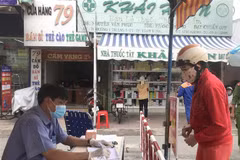 Lực lượng chức năng kiểm soát đối với người ra vào chợ Vĩnh Long, hạn chế tụ tập đông người. (Ảnh: Lê Thúy Hằng/TTXVN)
