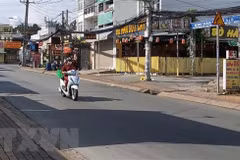 Người đi giao hàng cho các hộ dân theo khung giờ khu vực đường Đình Phong Phú, thành phố Thủ Đức, Thành phố Hồ Chí Minh. (Ảnh: Hồng Nhung/TTXVN)