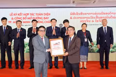 Tổng giám đốc Vietjet Đinh Việt Phương (trái) nhận Chứng nhận mở đường bay TP.HCM-Vientiane từ Phó Tổng Cục trưởng Cục Hàng không Dân dụng Lào Bounteng Symoon. (Ảnh: Doãn Tấn/TTXVN)