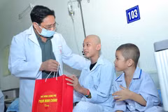 Thủ tướng Phạm Minh Chính động viên và tặng quà cho bệnh nhi đang điều trị nội trú tại Viện Huyết học và Truyền máu Trung ương. (Ảnh: Hoàng Hiếu/TTXVN)