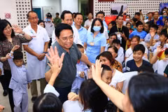 Thủ tướng Phạm Minh Chính thăm hỏi, động viên các bệnh nhi và người thân. (Ảnh: Hoàng Hiếu/TTXVN)