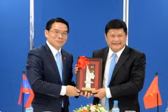 Ông Vilayvong Bouddakham (trái) tặng quà lưu niệm cho ông Huỳnh Cách Mạng. (Ảnh: Xuân Khu/TTXVN)
