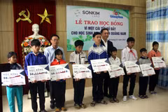 Ông Lê Văn Nhi, Tổng Biên tập Báo Quảng Nam cùng lãnh đạo Công ty SonKim Land trao học bổng cho các em học sinh. (Ảnh: Trịnh Bang Nhiệm/TTXVN)