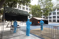 Nhân viên trực bên trong khu cách ly báo cáo với Chỉ huy trưởng về công tác quản lý, giám sát các trường hợp thực hiện cách ly tại điểm cách ly tập trung, trường Tiểu học Phú Thượng, quận Tây Hồ. (Ảnh: Minh Quyết/TTXVN) 